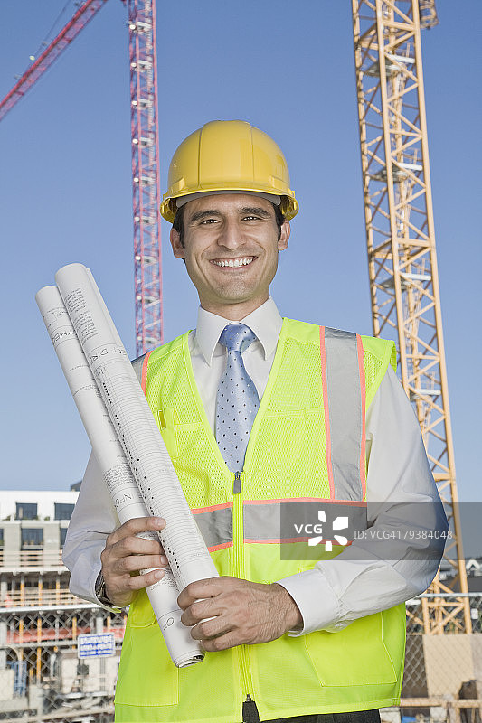 西班牙裔建筑工人拿着蓝图图片素材