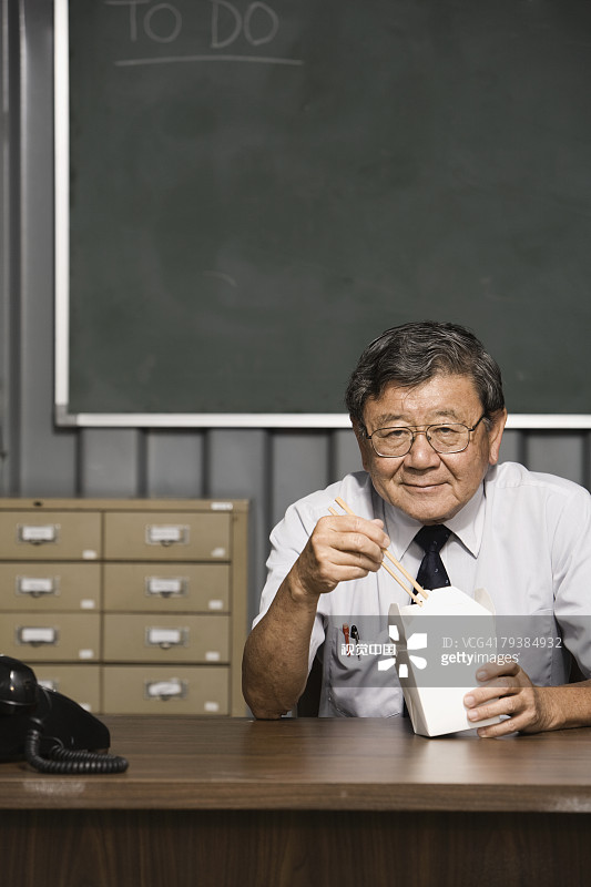 资深亚洲商人在吃外卖图片素材
