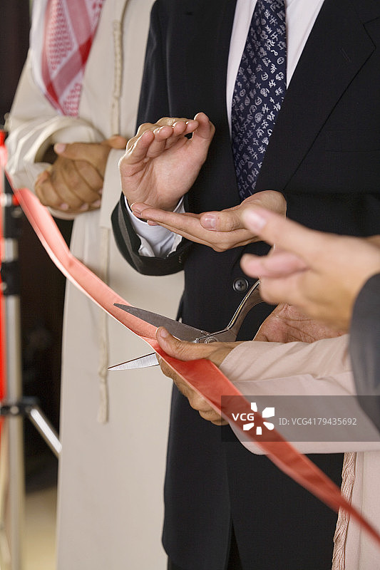 在剪彩仪式上为一位阿拉伯商人鼓掌的商人们图片素材