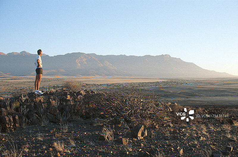 男人站在土堆上欣赏风景，纳米比亚西北部布兰德 berg 山图片素材