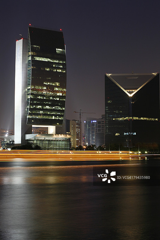 迪拜河黄昏时分，阿拉伯单桅三角帆船驶过迪拜国家银行，阿拉伯联合酋长国迪拜图片素材