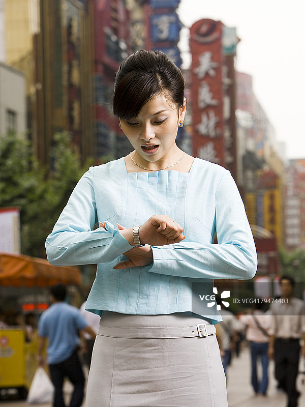 女人难以置信地看着手表图片素材