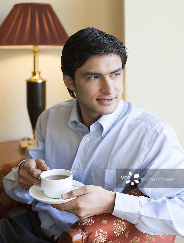 手持茶杯的年轻男子特写图片素材