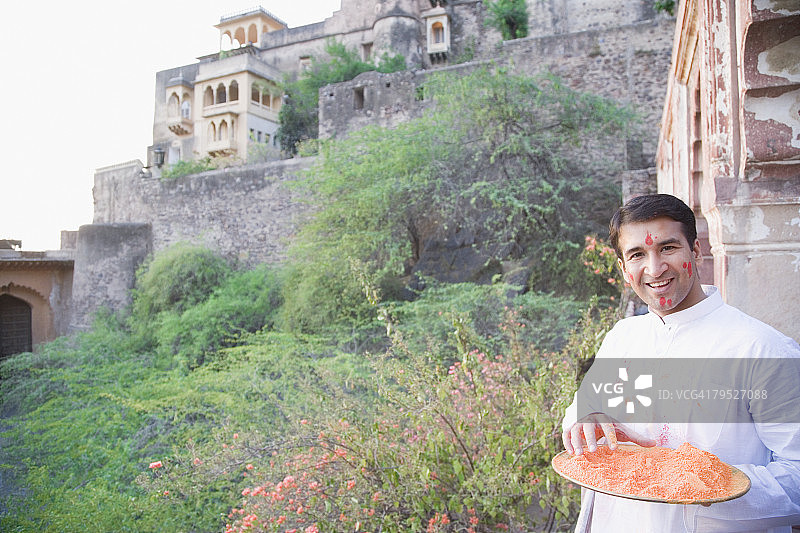 印度拉贾斯坦邦尼姆拉纳堡宫，手持颜料粉盘子微笑的中年男人肖像图片素材