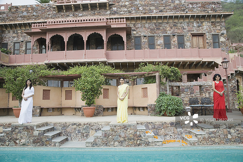 三个年轻女子站在印度拉贾斯坦邦阿尔瓦尔内姆拉纳堡宫的泳池边图片素材