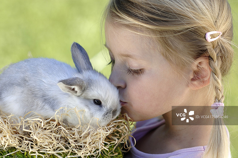 亲吻复活节兔子的6-7岁女孩图片素材
