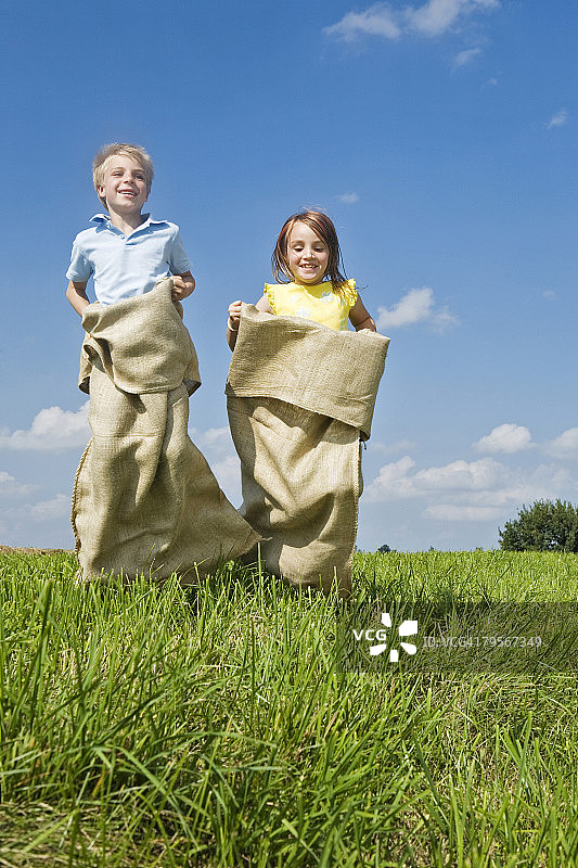 男孩和女孩麻袋赛跑图片素材