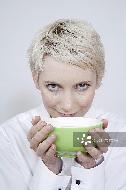 年轻女子手持茶碗的肖像图片素材