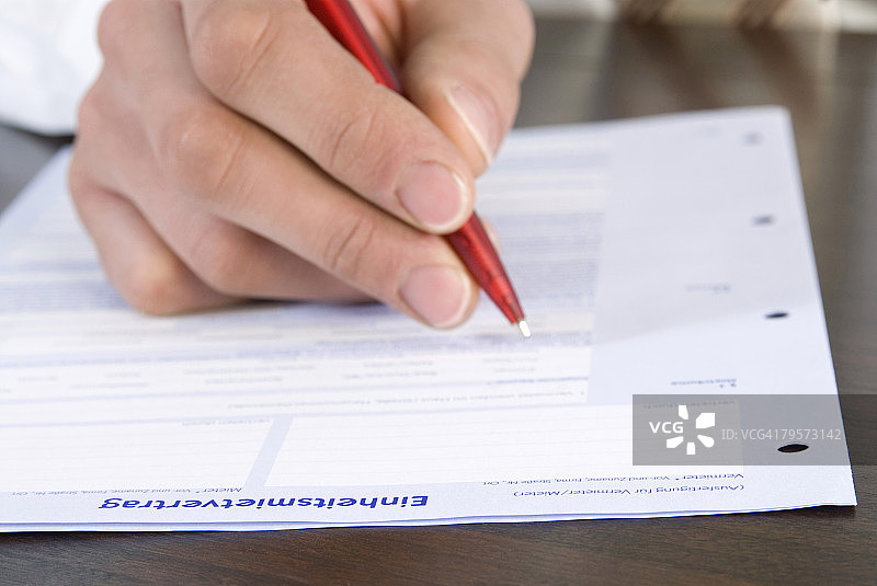 男子填写申请表，手部特写图片素材