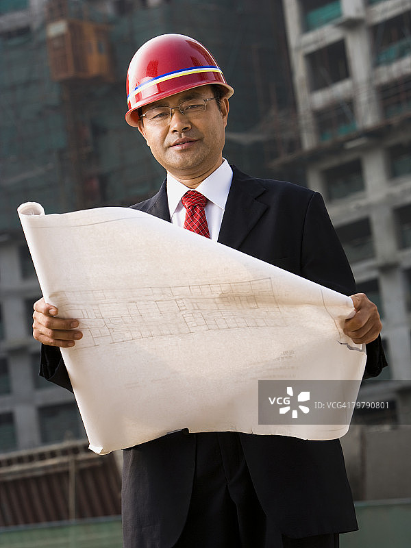 在户外使用蓝图的建筑工地工头图片素材