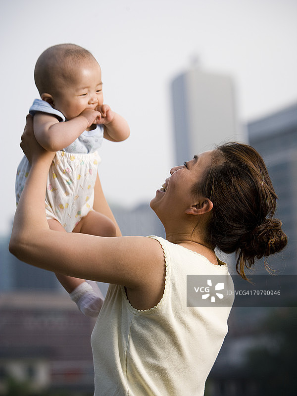 女人在户外抱着婴儿微笑图片素材