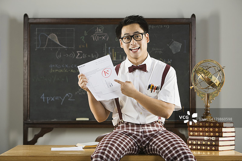 拿着A+成绩单的亚洲男学生图片素材
