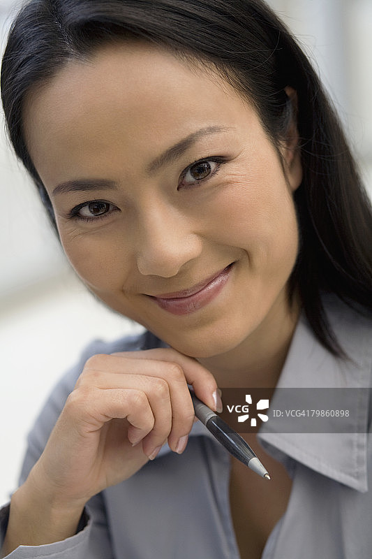 亚洲女商人拿着笔图片素材