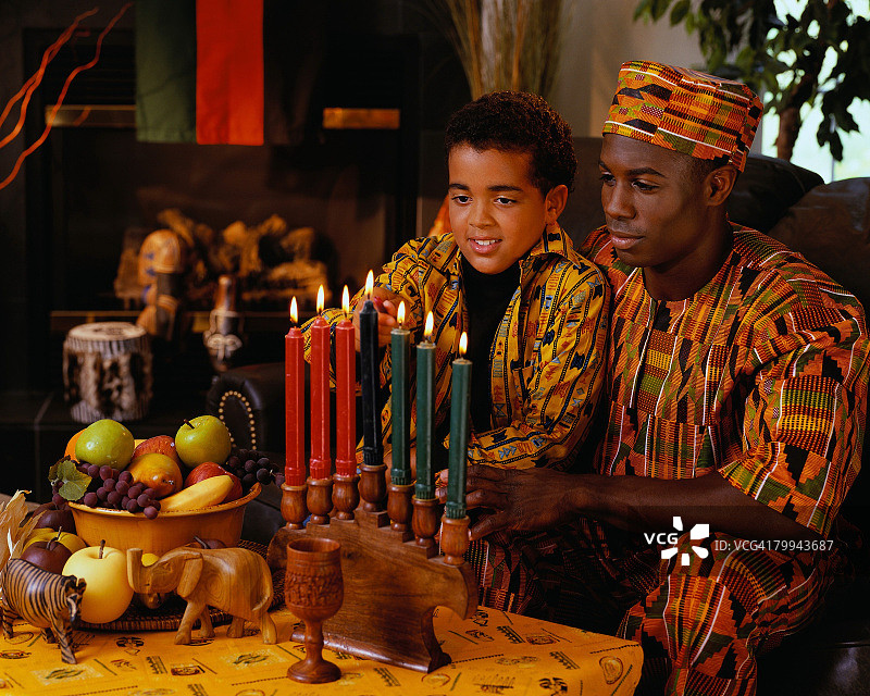 父亲看着儿子点燃蜡烛图片素材