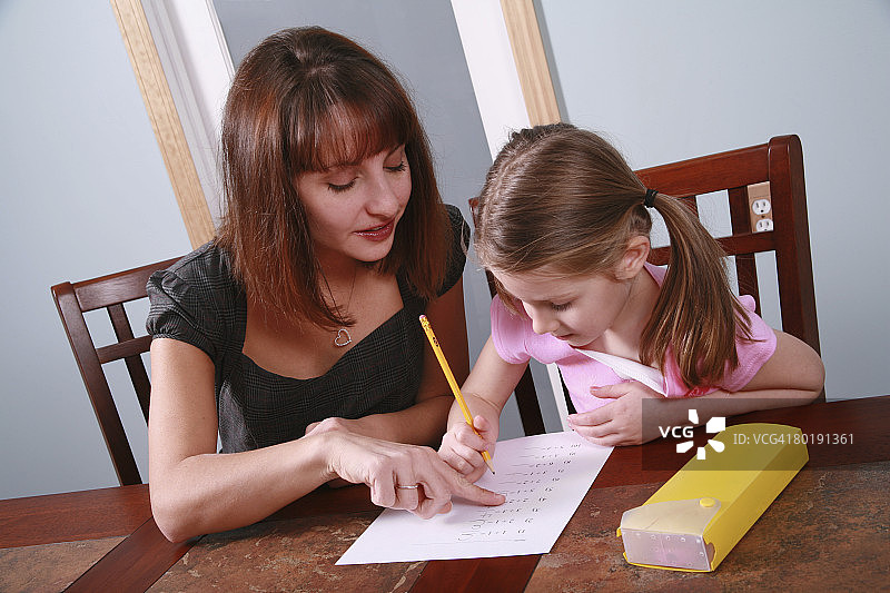 女人辅导孩子做数学作业图片素材
