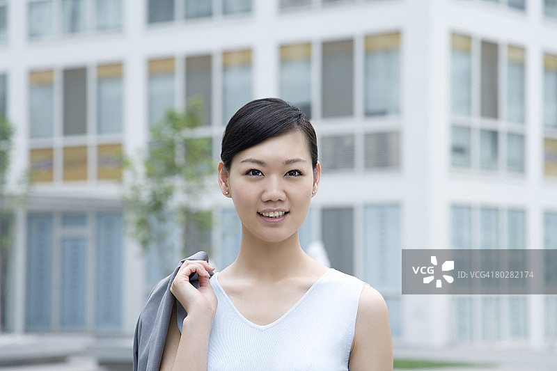 女商人看着镜头，背景是建筑物，焦点差异，中国北京图片素材