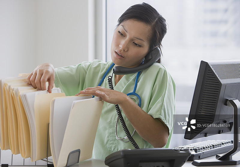 亚洲女医生在打电话图片素材