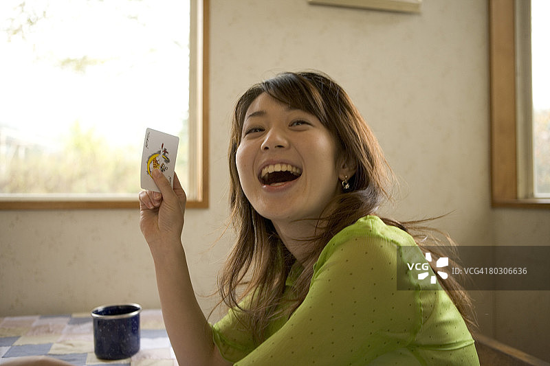 手拿扑克牌的欢笑女孩图片素材