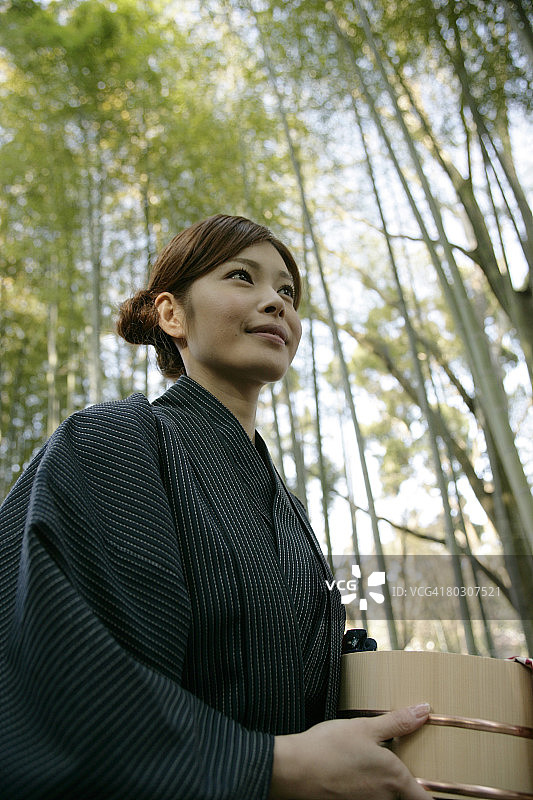 站在花园里拿着水桶的女人（低角度）图片素材
