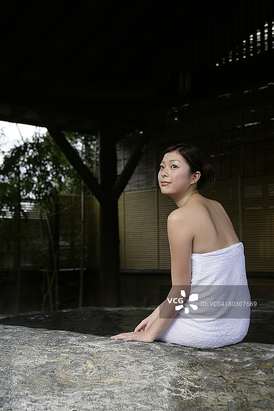 女人坐在热水浴缸旁图片素材