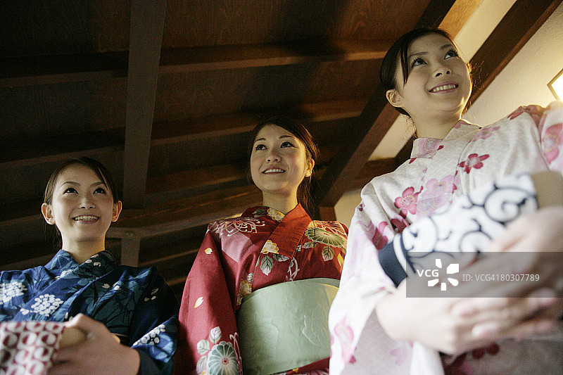 三名身穿和服的女子站在走廊上，低角度拍摄图片素材