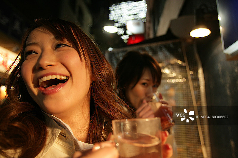 两名女子在夜晚喝啤酒图片素材
