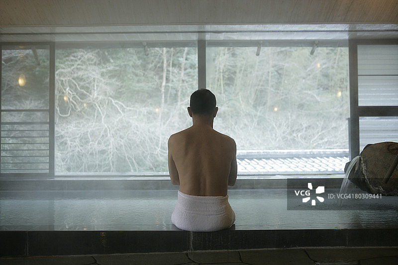 男人坐在按摩浴缸里，后视图图片素材