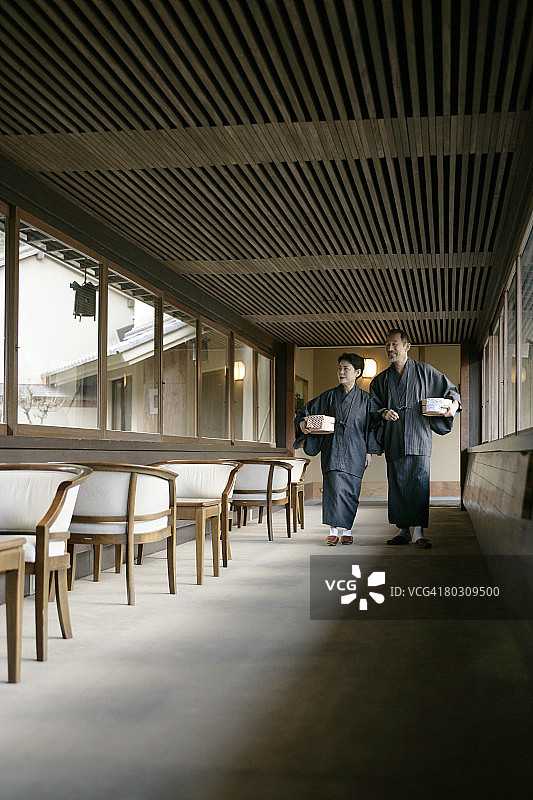 老年夫妇提着水桶走在走廊上图片素材