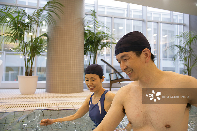 中年夫妇在游泳池里放松图片素材