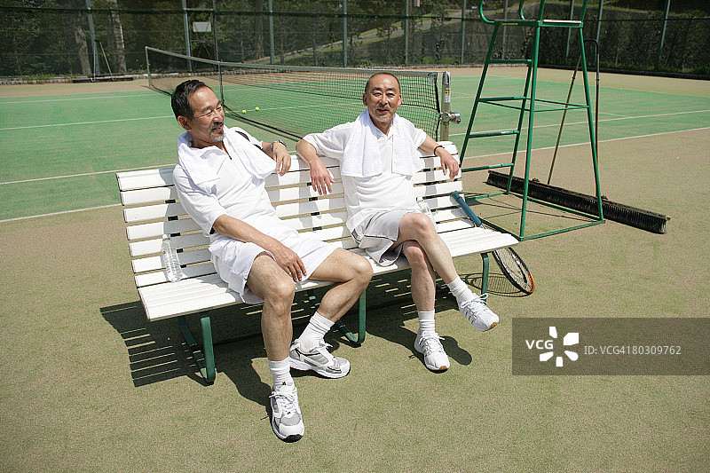 两位中年男人坐在网球场的长椅上图片素材