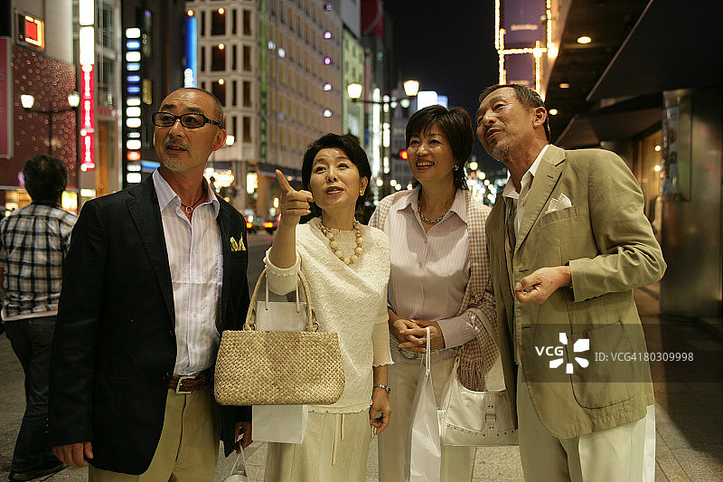 四名成年人站在夜晚的街道上图片素材