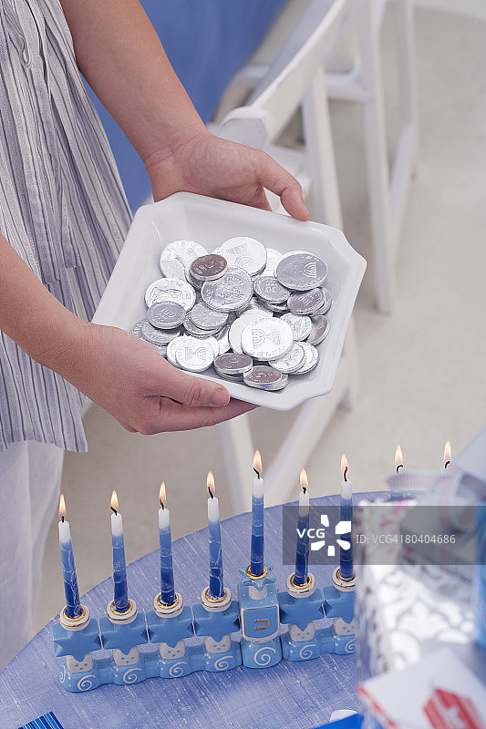 手拿光明节金币和烛台图片素材