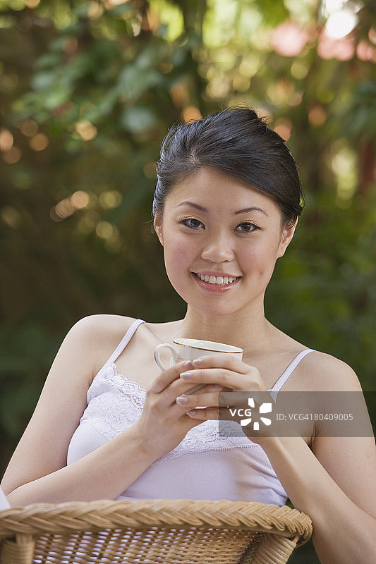 在户外喝茶的微笑女人图片素材