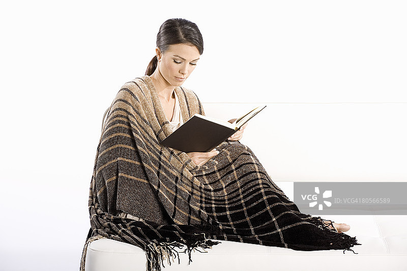 女人裹着毯子读书图片素材