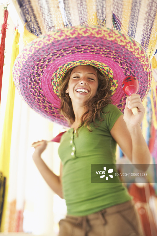 戴着墨西哥帽玩沙槌的女人图片素材