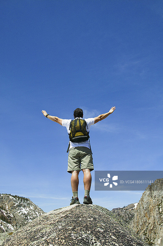 张开双臂站在山顶的男人图片素材
