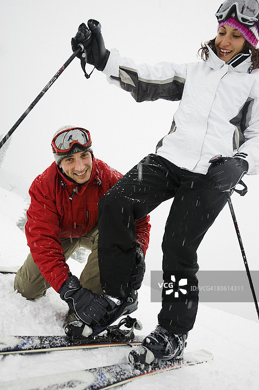 男子帮助女子滑雪图片素材