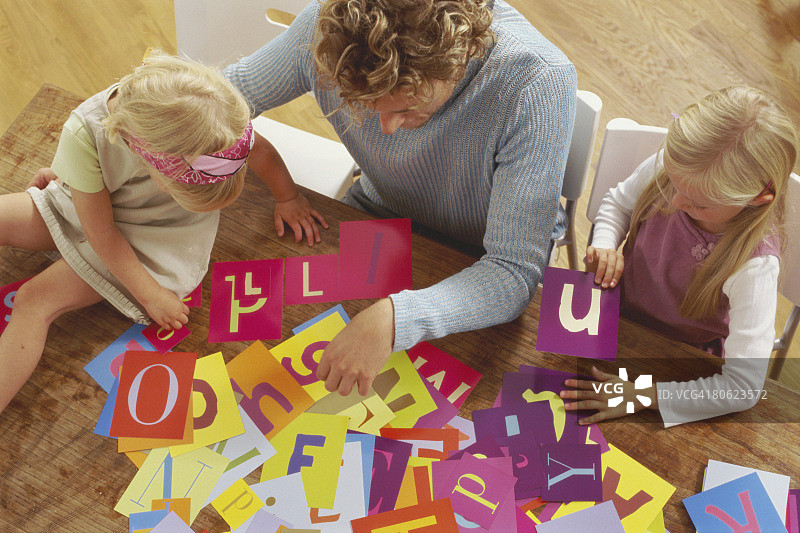 父亲和两个女儿一起玩字母图片素材