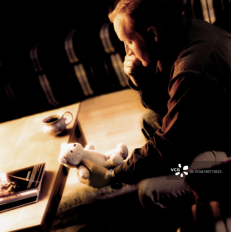 男人手持泰迪熊图片素材