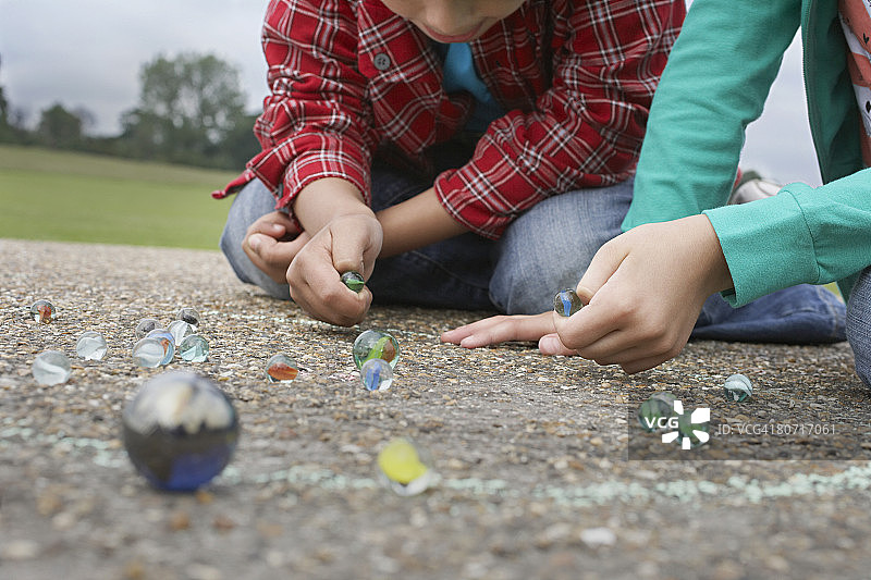 男孩和女孩玩玻璃弹珠图片素材