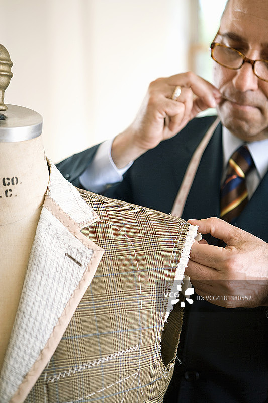 裁缝别住男士外套的肩膀图片素材