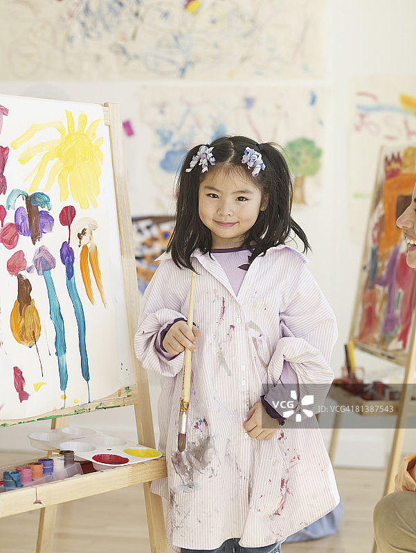 在画架旁绘画的亚洲女孩图片素材
