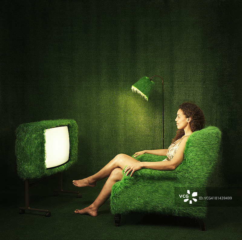 带有草皮电视的绿色房间，一位女士正在观看图片素材