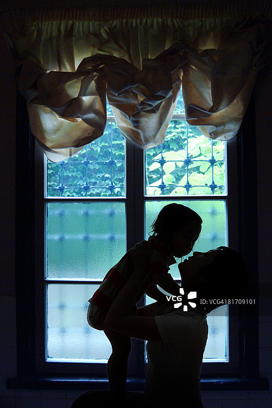 年轻母亲抱着女儿的剪影图片素材