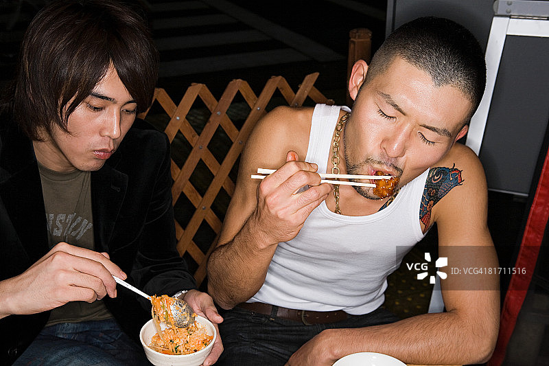 年轻男人吃日本料理图片素材