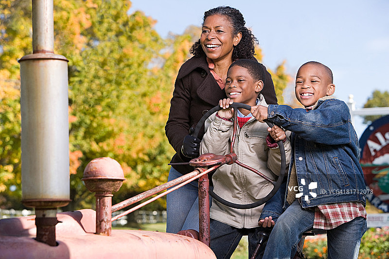 男孩和奶奶在拖拉机上玩耍图片素材