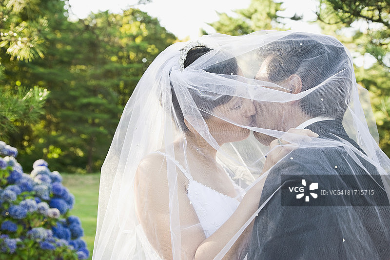 正在接吻的亚洲新婚夫妇图片素材