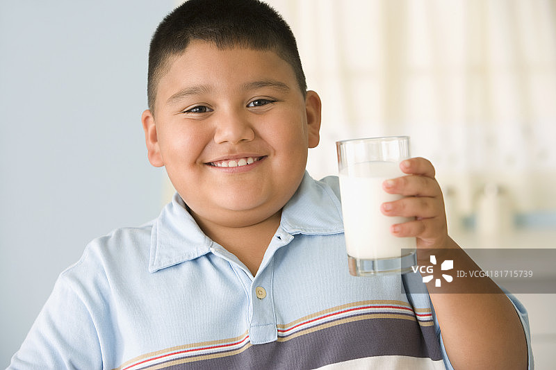 拿着一杯牛奶的西班牙裔男孩图片素材