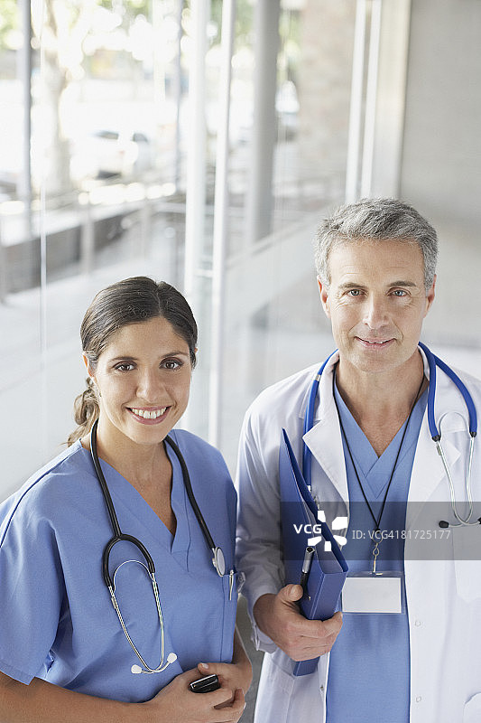 两名医护人员在走廊里拿着手机微笑图片素材