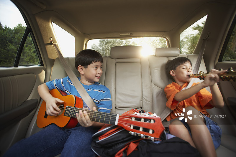 在后座上玩音乐的小男孩图片素材